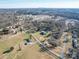 Aerial view of a community with single-Gathering homes, trees, and a skyline in the distance at 7169 Pleasant Grove Rd, Charlotte, NC 28216