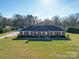 Beautiful brick home with mature lawn, detached garage, and well-maintained landscaping at 7169 Pleasant Grove Rd, Charlotte, NC 28216