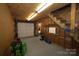 Unfinished garage area with stairs to upper level, and door to outside at 7169 Pleasant Grove Rd, Charlotte, NC 28216