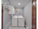 Bright laundry room with washer, dryer, and storage at 7169 Pleasant Grove Rd, Charlotte, NC 28216