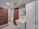 Clean laundry room with utility sink and storage at 7169 Pleasant Grove Rd, Charlotte, NC 28216