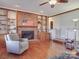 Living room with a brick fireplace, built-in shelving, and hardwood floors at 7169 Pleasant Grove Rd, Charlotte, NC 28216