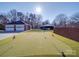 Backyard putting green with well-manicured artificial turf and US flags at 7169 Pleasant Grove Rd, Charlotte, NC 28216