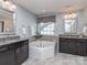 A modern bathroom with a corner tub, granite countertops, and dual sinks at 7607 Quilbray Dr, Huntersville, NC 28078