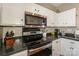 Stainless steel appliances and dark countertops in this kitchen at 11231 Heritage Green Dr, Cornelius, NC 28031