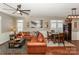 Living room with leather sectional sofa, hardwood floors, and large windows at 11231 Heritage Green Dr, Cornelius, NC 28031