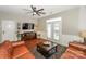 Living room with leather couches, wood floors, and a large TV at 11231 Heritage Green Dr, Cornelius, NC 28031