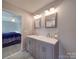 Updated bathroom with double vanity and view into bedroom at 114 W Lee Ave, Bessemer City, NC 28016