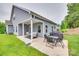 Well-manicured backyard featuring an outdoor seating area, grill, and mature trees offering shade and privacy at 15298 Windward Ln, Lancaster, SC 29720