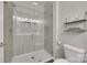 Bright bathroom showcases a glass shower, toilet, and a stylish shelf with decorative elements at 15298 Windward Ln, Lancaster, SC 29720