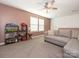Spacious bonus room with plush carpet, large windows, and ceiling fan at 15298 Windward Ln, Lancaster, SC 29720