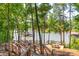 Wooden deck stairs leading down to a lakefront patio at 15298 Windward Ln, Lancaster, SC 29720