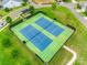 Aerial view of pristine blue and green tennis courts with surrounding greenery and neighborhood views at 15298 Windward Ln, Lancaster, SC 29720