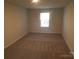 Simple bedroom with neutral-colored carpet and a window at 1827 Mcdonald St, Charlotte, NC 28216