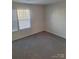 Bright bedroom with neutral carpeting and a large window at 1827 Mcdonald St, Charlotte, NC 28216