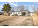 Front view of a gray brick ranch house with a yard and driveway at 2016 W Arrowood Rd, Charlotte, NC 28217