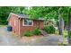 Side view of a brick ranch house with a gravel driveway and green trees at 61 17Th Street Nw Pl, Hickory, NC 28601