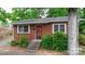 Brick ranch house with steps leading to the front door, surrounded by lush greenery at 61 17Th Street Nw Pl, Hickory, NC 28601