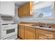 View of kitchen with wood cabinets, white appliances, and a double sink at 61 17Th Street Nw Pl, Hickory, NC 28601