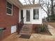 Exterior view of back porch with brick steps, a white door with glass, and a railing leading to the yard at 2044 Helen Dr, Gastonia, NC 28054