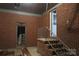 Unfinished basement with brick walls, concrete floor, and interior staircase at 2044 Helen Dr, Gastonia, NC 28054