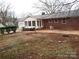 Brick ranch house with sunroom addition, patio, and mature landscaping at 2044 Helen Dr, Gastonia, NC 28054