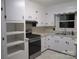 Updated kitchen boasts stainless steel appliances, white cabinets, and convenient built-in shelving for ample storage at 2044 Helen Dr, Gastonia, NC 28054