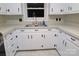 Well-lit kitchen showcasing classic white cabinets, stainless steel sink, and efficient layout at 2044 Helen Dr, Gastonia, NC 28054