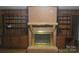 Cozy living room showcasing a brick fireplace with built-in wooden shelving on each side offering warmth and storage at 2044 Helen Dr, Gastonia, NC 28054