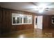 Bright and airy living room showcasing hardwood floors, paneled walls, a ceiling fan, and access to other rooms at 2044 Helen Dr, Gastonia, NC 28054