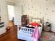 Charming bedroom with hardwood floors, white bed, and playful decor at 217 Brent St, Wadesboro, NC 28170