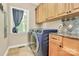 Bright laundry room with washer, dryer, and ample cabinetry at 227 Wildwood Cove Dr, Mooresville, NC 28117