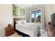 Comfortable bedroom with a wooden bed frame and large window at 3630 N Davidson St # 4413, Charlotte, NC 28205