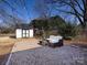 Backyard features a gravel patio area with outdoor furniture and shed under string lights at 4837 Holbrook Dr, Charlotte, NC 28212
