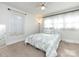 Bright bedroom features a ceiling fan, neutral carpet and walls, and sheer white curtains at 4837 Holbrook Dr, Charlotte, NC 28212