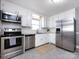 Well-lit kitchen features stainless steel appliances, white cabinets, and modern backsplash at 4837 Holbrook Dr, Charlotte, NC 28212