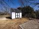 Backyard shed with black trim and modern doors situated on a manicured lawn at 4837 Holbrook Dr, Charlotte, NC 28212