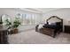 Tranquil bedroom with a large window showcasing a serene view, complemented by a dark wood bed at 6124 Music Arbor Ln, Huntersville, NC 28078
