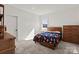 Bright bedroom featuring a wood-framed bed with a colorful comforter and a view of the outdoors at 6124 Music Arbor Ln, Huntersville, NC 28078
