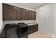 Functional laundry room with dark wood cabinets, granite countertops, and modern washer and dryer at 6124 Music Arbor Ln, Huntersville, NC 28078