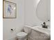 Stylish powder room featuring a round mirror, pedestal sink, and elegant wall art, creating a refined space at 6124 Music Arbor Ln, Huntersville, NC 28078