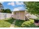 Tan storage shed with a white door and decorative metal accent at 8244 Fox Swamp Rd, Charlotte, NC 28215