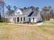 White farmhouse with a side view showcasing landscaping and a detached shed at 0000 Trull Hinson Rd, Wingate, NC 28174