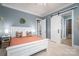 Bright bedroom with a white bed frame and coral bedding, barn door, and ensuite bathroom at 104 Cramer Mountain Woods None, Cramerton, NC 28032