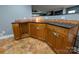 Basement bar with wood cabinets, granite countertop, and wine rack at 327 Johnson Dairy Rd, Mooresville, NC 28115
