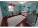 Bedroom with teal walls, gray crib, and decorative flowers at 327 Johnson Dairy Rd, Mooresville, NC 28115