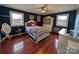 Bedroom with hardwood floors, white crib, and navy blue walls at 327 Johnson Dairy Rd, Mooresville, NC 28115