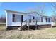 Front view of a white mobile home with brown shutters and a wooden deck at 3463 Rock Creek Dr, Newton, NC 28658