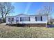 White single-wide mobile home with brown shutters and a wooden deck at 3463 Rock Creek Dr, Newton, NC 28658