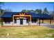 Gray metal siding home with black metal roof, covered porch, and carport at 411 E Gary St, Candor, NC 27229